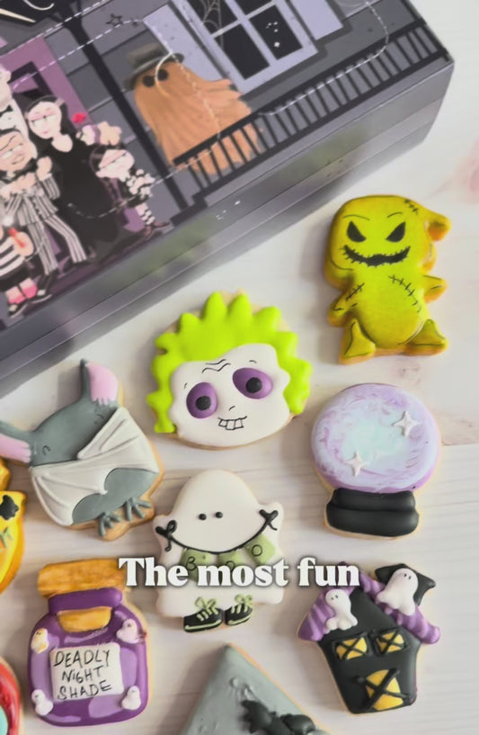 halloween cookie advent countdown calendar, a video shocasing the calendar box that has 12 windows and 12 assorted halloween decorated mini cookies