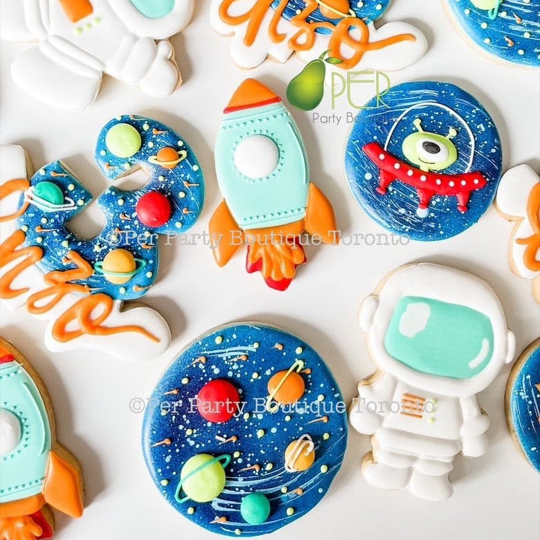 Colorful space-themed cookies with numbers and space-themed decorations on a white background